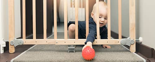 A child behind a safety gate.
