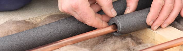 Copper pipes being fitted with insulation foam.